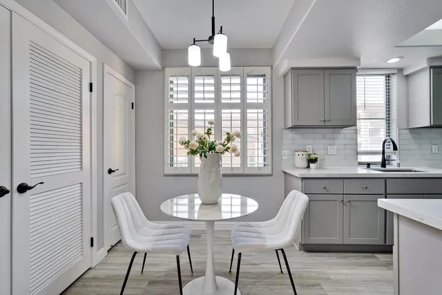 a kitchen with stainless steel appliances granite countertop a refrigerator a sink dishwasher with a dining table and chairs