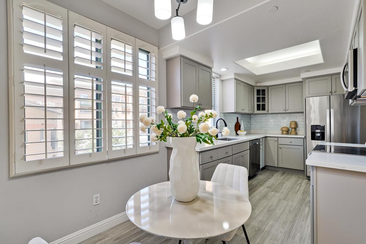 144 South 3rd Street, Unit 425 San Jose, CA 95112 - Photo 12 of 52 a kitchen with stainless steel appliances granite countertop a refrigerator a sink dishwasher with a dining table and chairs