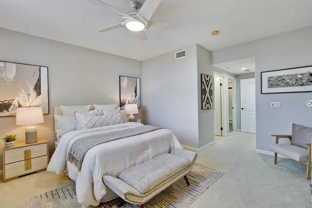 a bedroom with a bed and a potted plant