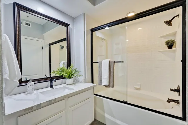 a bathroom with a granite countertop sink a toilet and mirror
