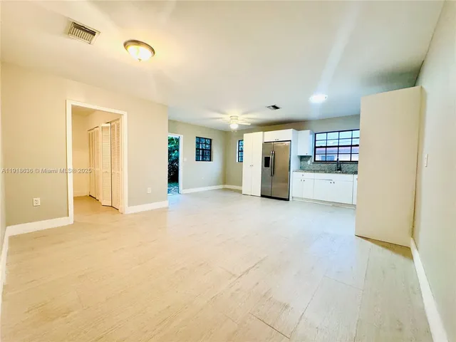 a view of a kitchen with refrigerator and cabinets