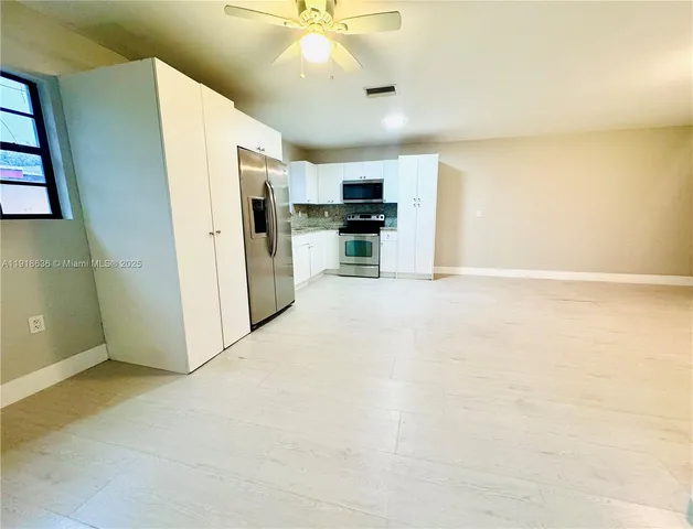 a view of a kitchen with a sink and a refrigerator