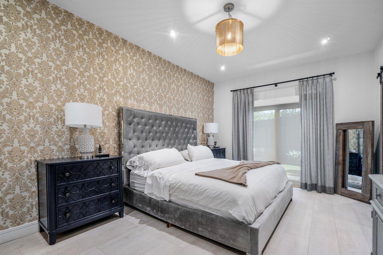 308 Enfield Road Delray Beach, FL 33444 - Photo 11 of 25 a bedroom with a bed and a chandelier