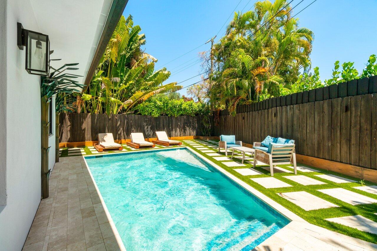 308 Enfield Road Delray Beach, FL 33444 - Photo 16 of 25 a view of a swimming pool with a patio and a garden