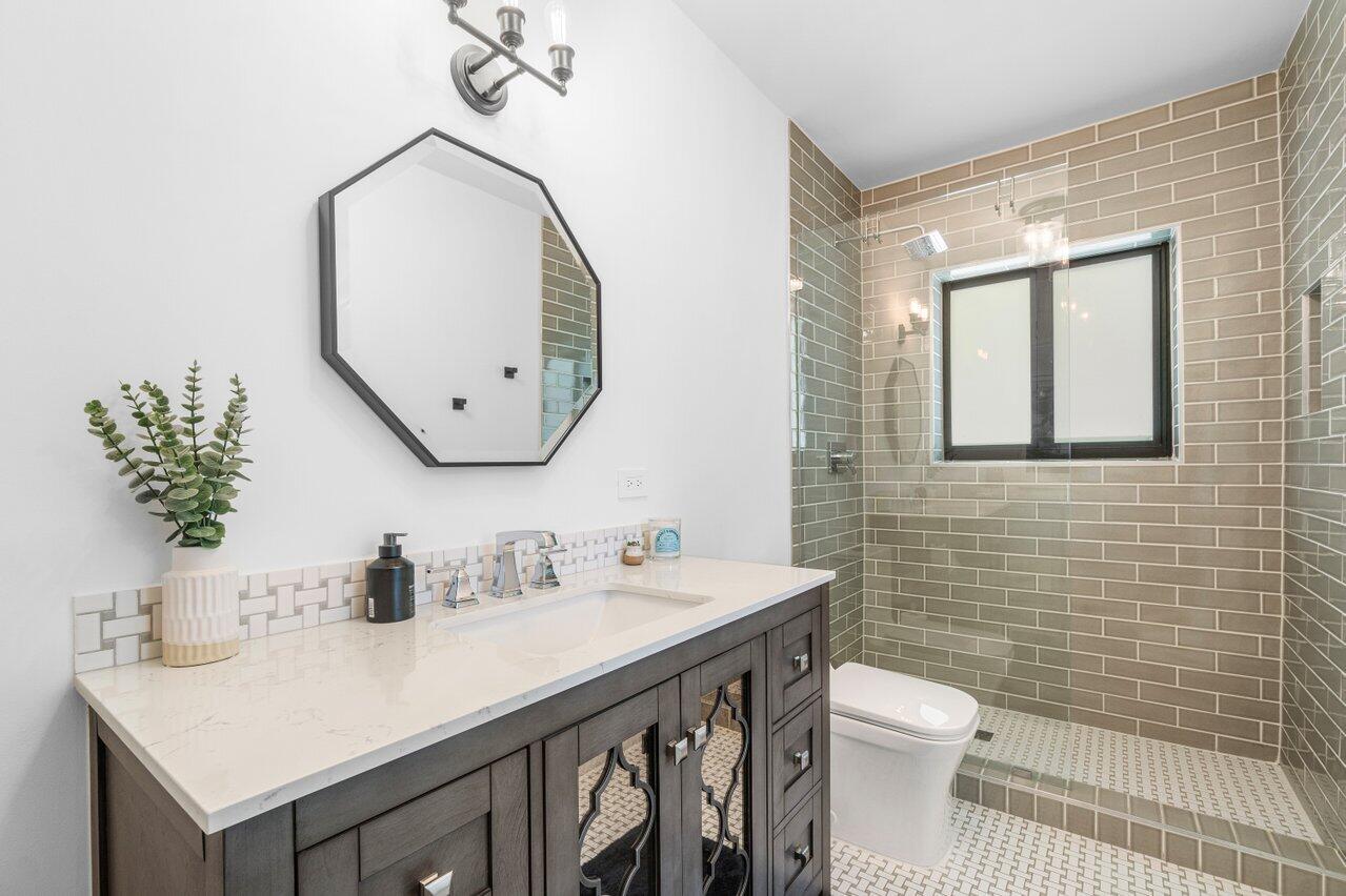 308 Enfield Road Delray Beach, FL 33444 - Photo 20 of 25 a bathroom with a sink mirror and toilet
