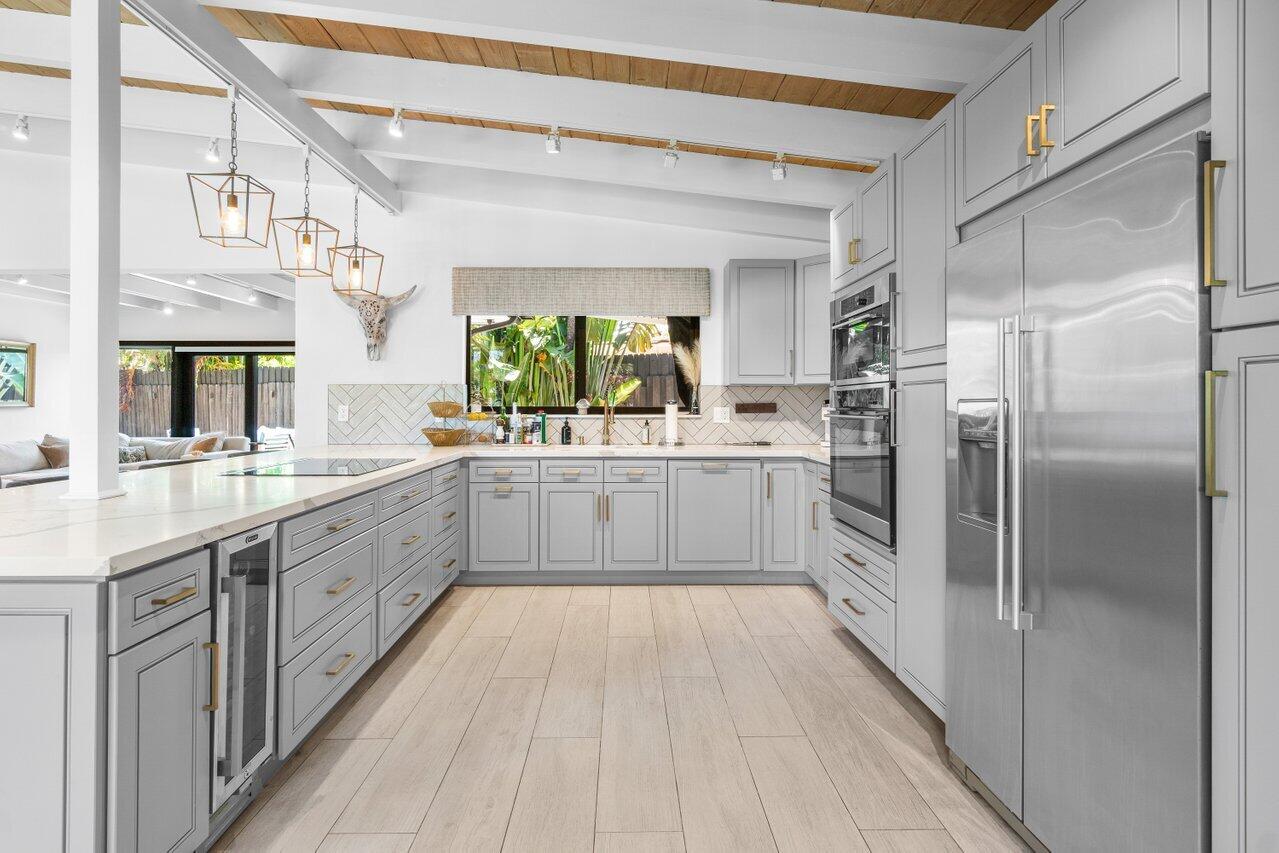 308 Enfield Road Delray Beach, FL 33444 - Photo 9 of 25 a large white kitchen with a large window a sink and stainless steel appliances