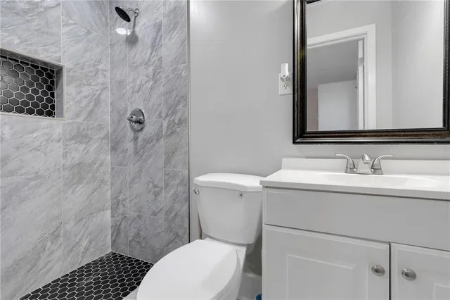 a bathroom with a sink a toilet and shower