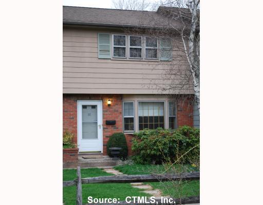 161 Spring Street, Unit 161 Wethersfield, CT 06109 - Photo 1 of 1 a view of a house with brick walls and a yard with plants