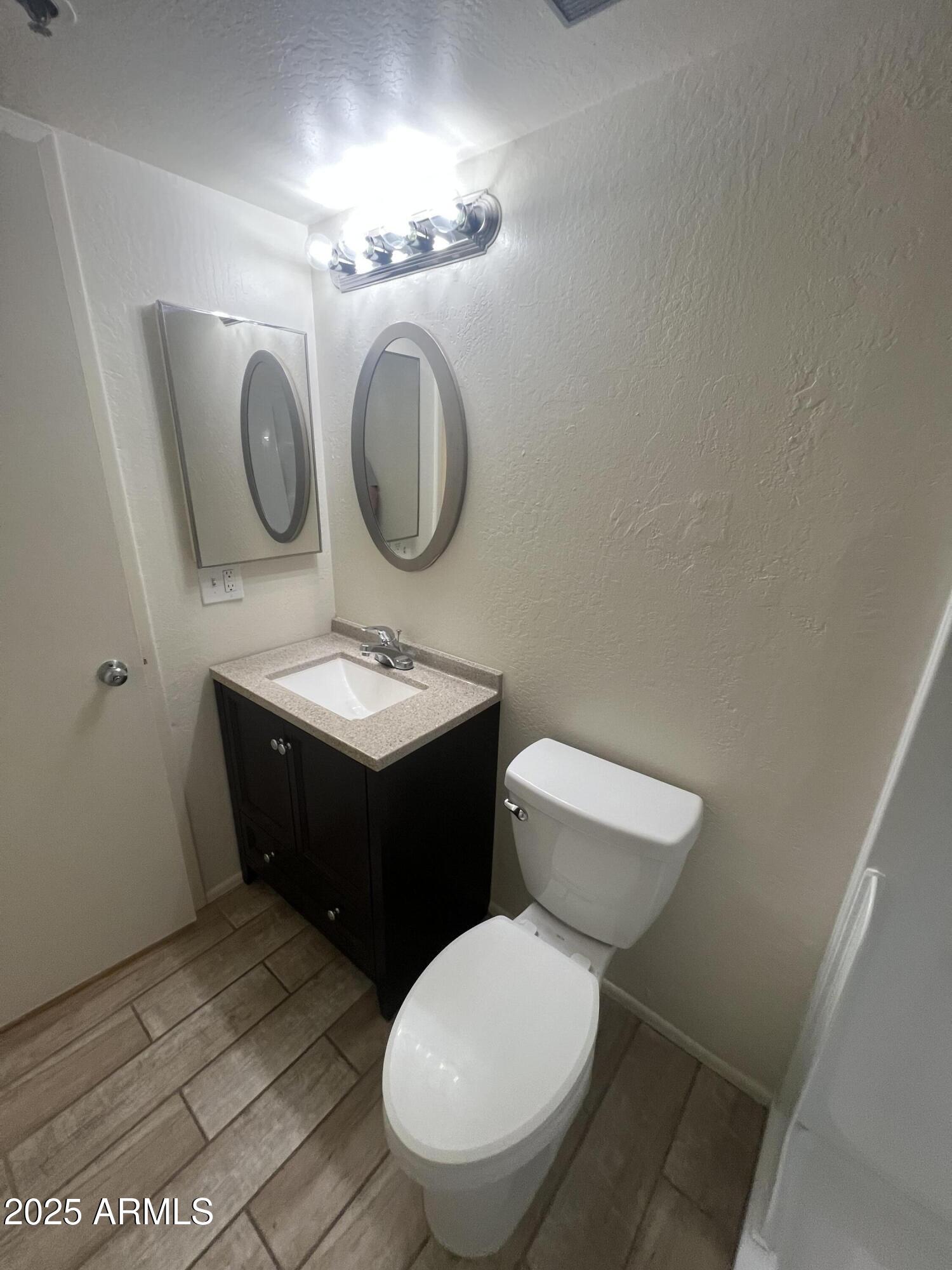12221 West Bell Road, Unit 278 Surprise, AZ 85378 - Photo 19 of 24 a bathroom with a toilet a sink and a mirror