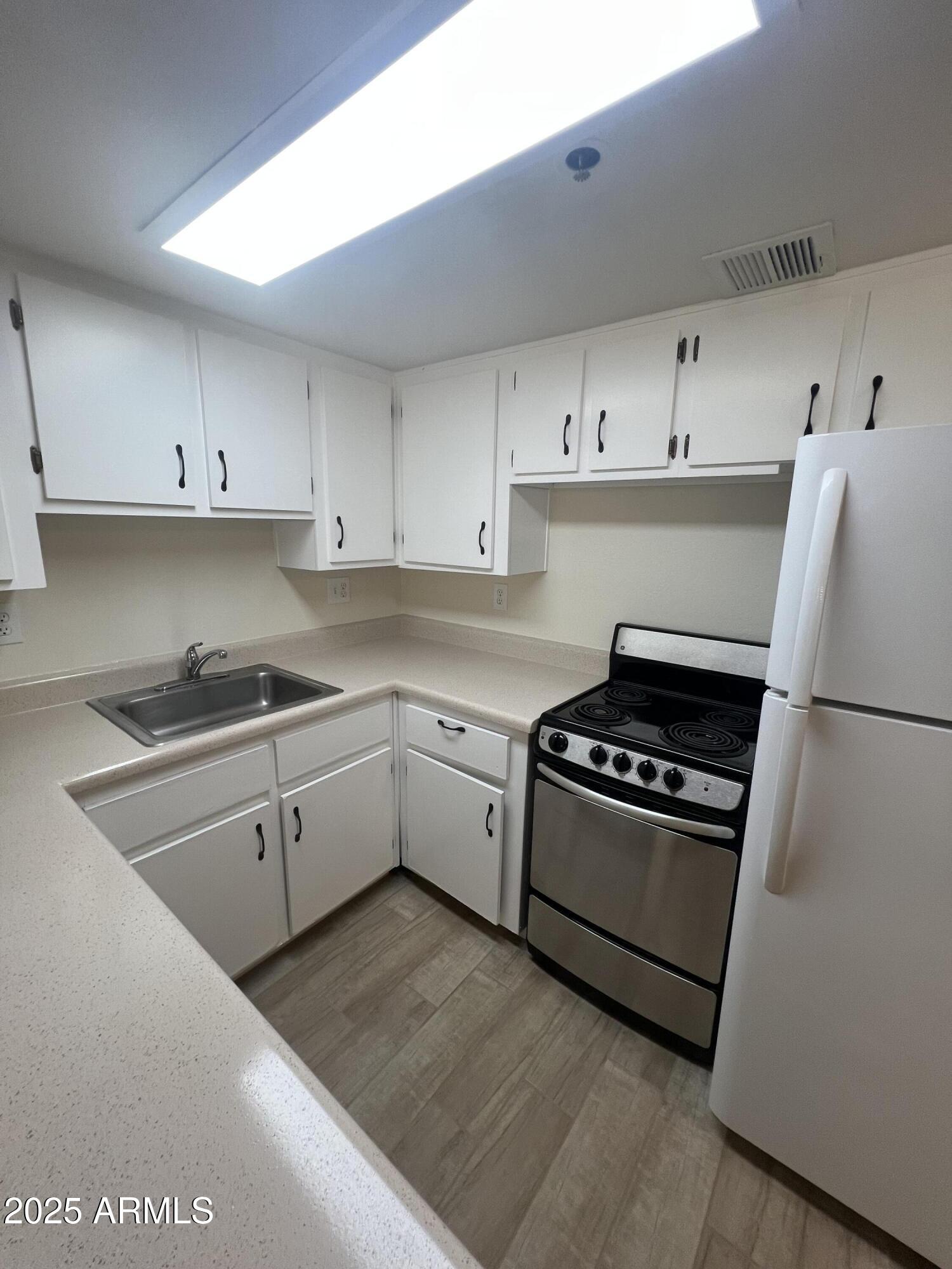 12221 West Bell Road, Unit 278 Surprise, AZ 85378 - Photo 9 of 24 a kitchen with cabinets appliances and a window