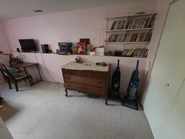 a bedroom with furniture and a book shelf