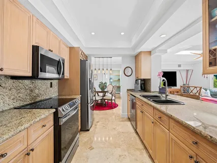 a kitchen with stainless steel appliances granite countertop a sink stove and refrigerator