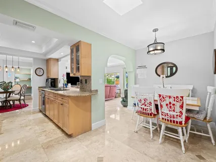 a living room filled with furniture and a dining table with wooden floor