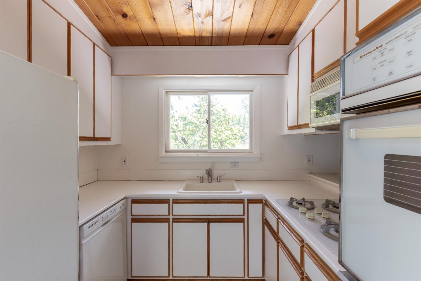 21661 Woolaroc Drive Los Gatos, CA 95033 - Photo 12 of 48 a view of cabinets a sink and a window in a kitchen
