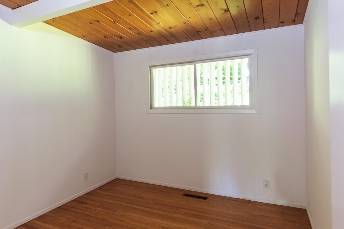 21661 Woolaroc Drive Los Gatos, CA 95033 - Photo 13 of 48 a view of an empty room with wooden floor and a window