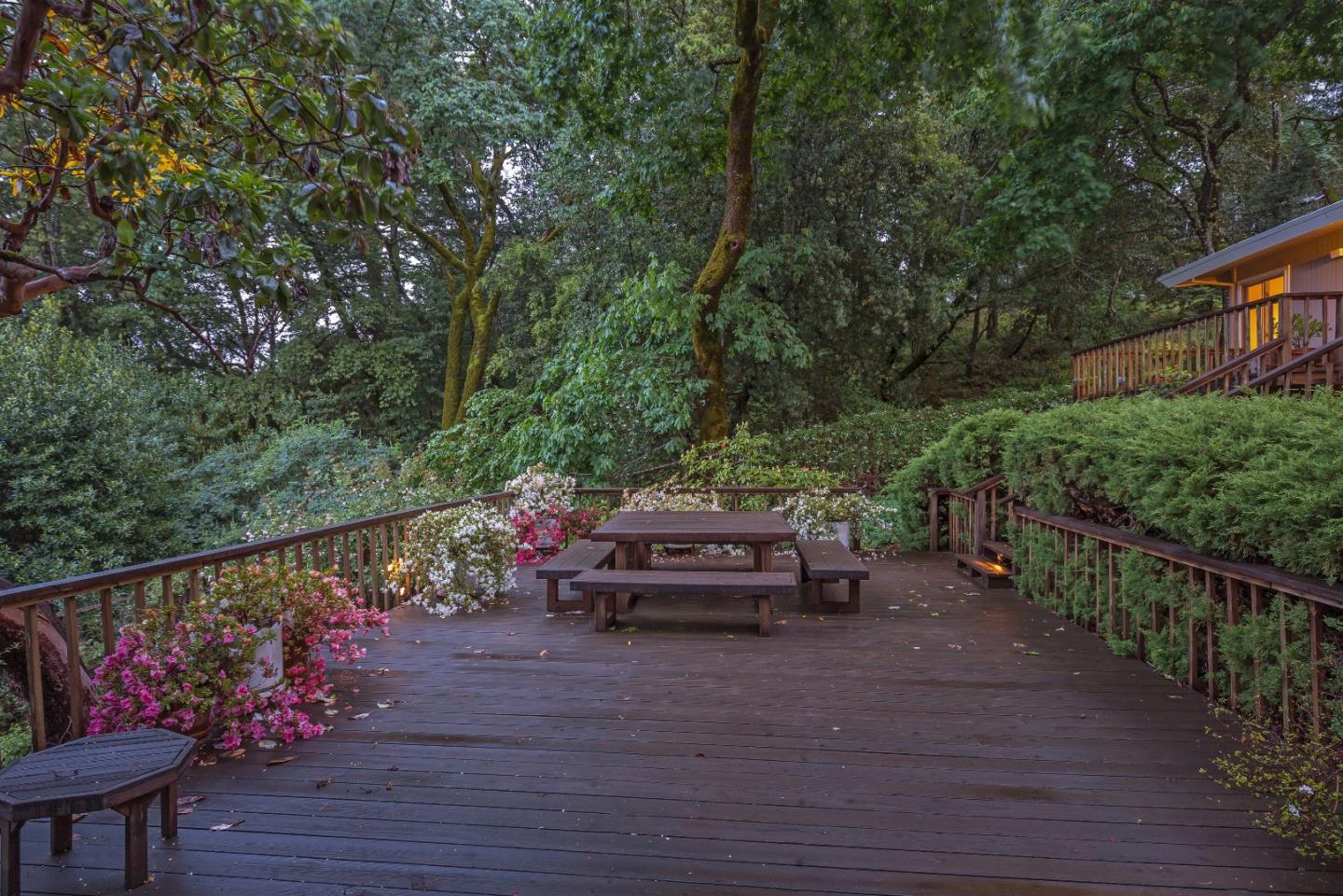 21661 Woolaroc Drive Los Gatos, CA 95033 - Photo 24 of 48 a view of a deck with couches table and chairs with wooden floor and fence