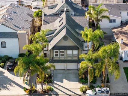 a front view of a house with a yard and potted plants