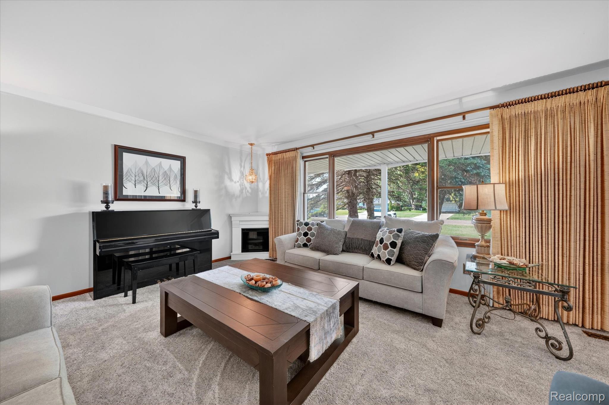 18178 22 Mile Road Macomb, MI 48044 - Photo 6 of 43 Spacious living area featuring light-colored carpeting, white wall paint, and a corner fireplace with a white mantel