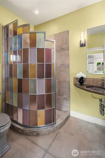 a view of a hallway with wooden floor and a bathroom