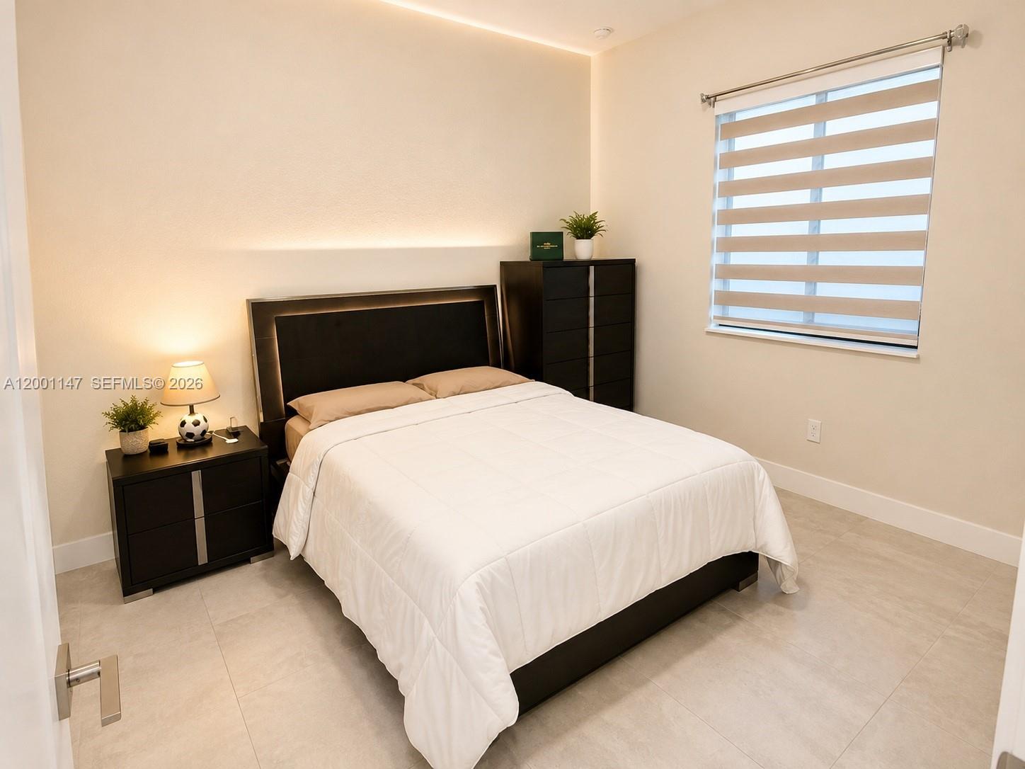 14531 Southwest 21st Street Miami, FL 33175 - Photo 11 of 25 a large bed sitting in a bedroom next to a window with lamp