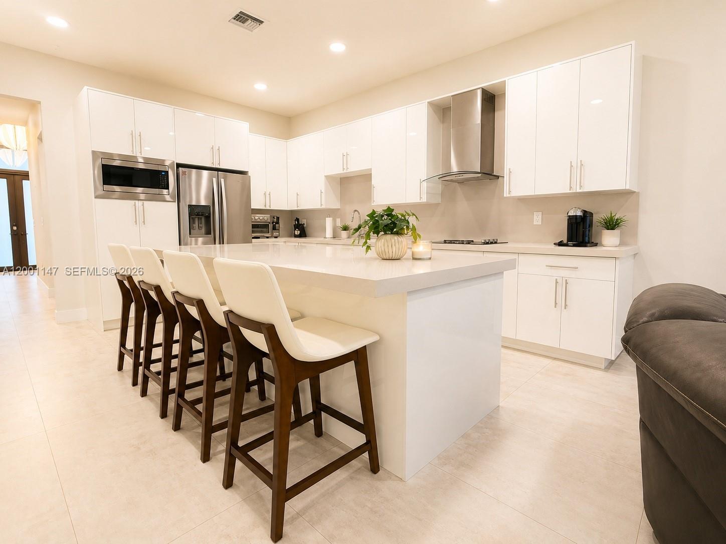 14531 Southwest 21st Street Miami, FL 33175 - Photo 14 of 25 a kitchen with stainless steel appliances kitchen island granite countertop a table chairs microwave and sink
