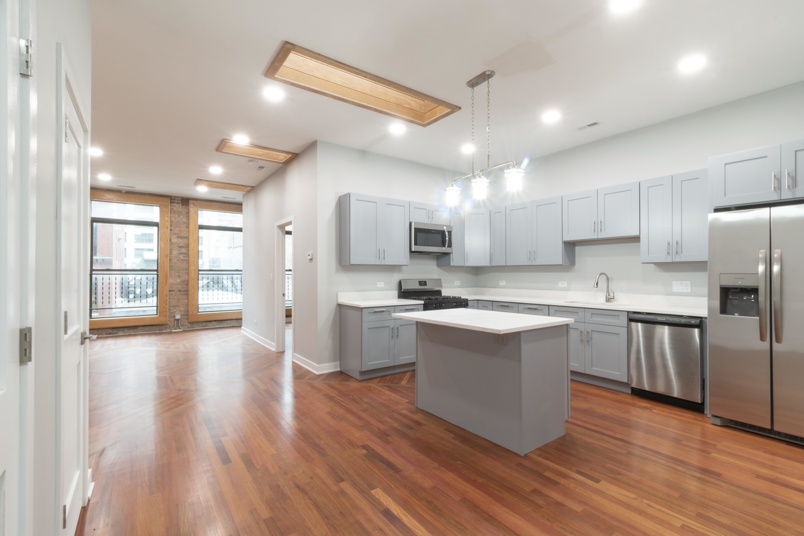 23 West Hubbard Street, Unit 4A Chicago, IL 60654 - Photo 2 of 8 a large kitchen with stainless steel appliances granite countertop a stove a sink dishwasher and a refrigerator with wooden floor