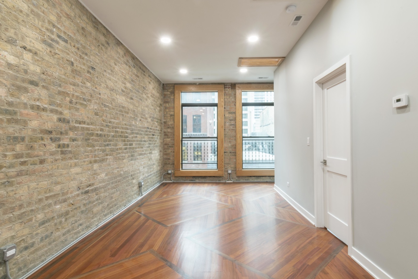 23 West Hubbard Street, Unit 4A Chicago, IL 60654 - Photo 4 of 8 a view of an empty room with wooden floor and a window