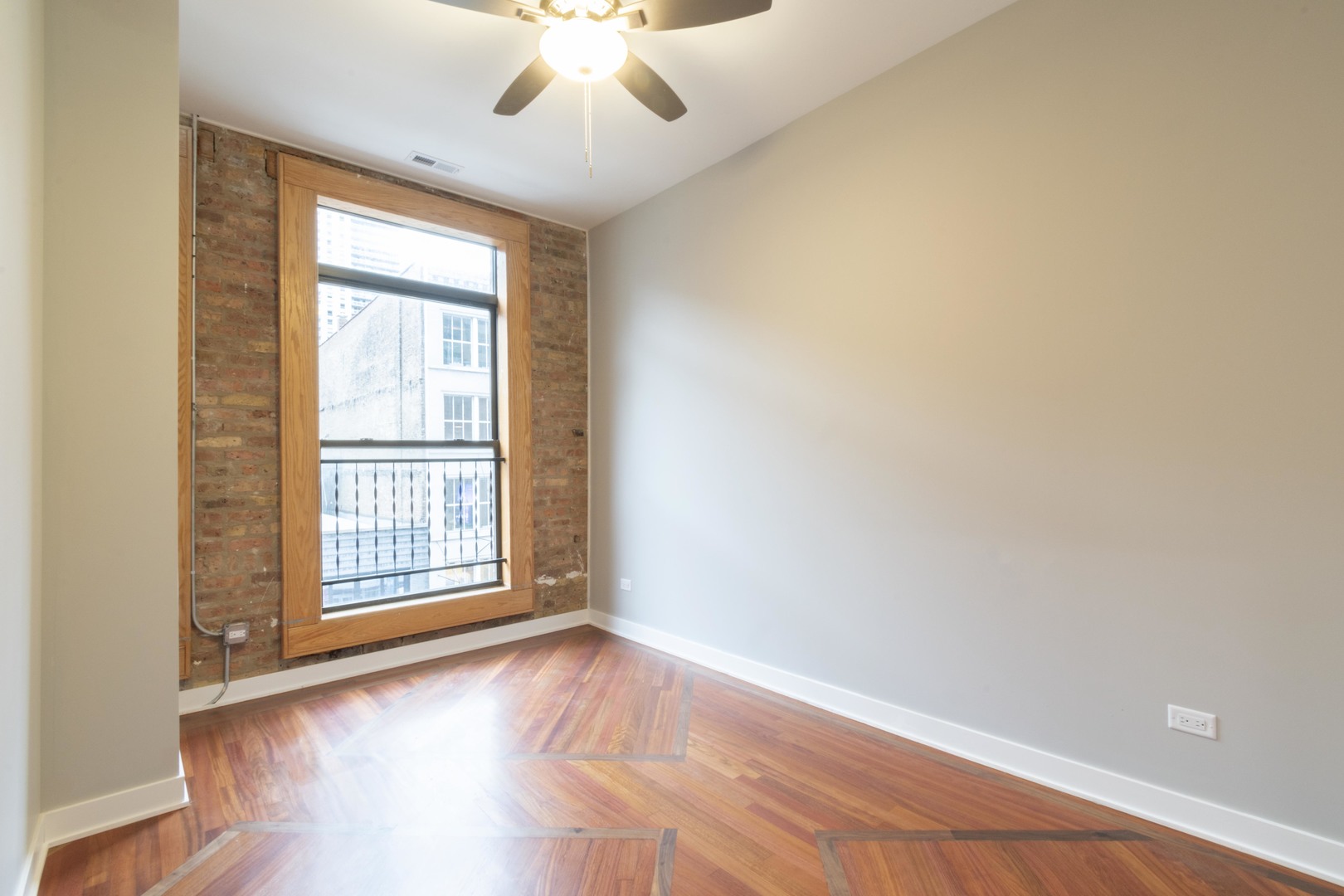 23 West Hubbard Street, Unit 4A Chicago, IL 60654 - Photo 5 of 8 an empty room with wooden floor and windows