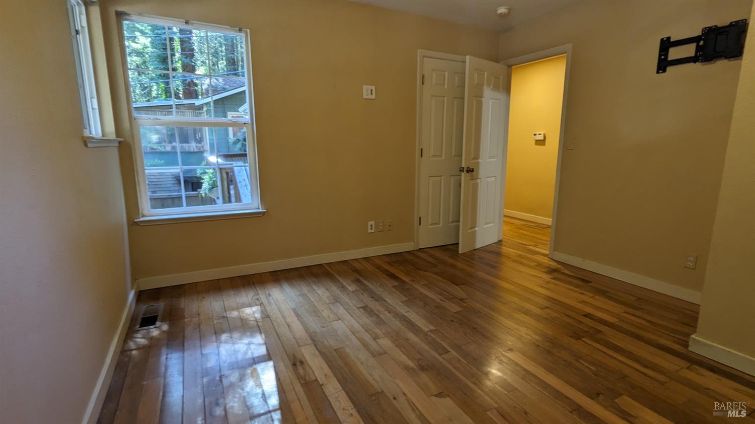 19026 Hidden Valley Road Guerneville, CA 95446 - Photo 14 of 23 an empty room with wooden floor and windows