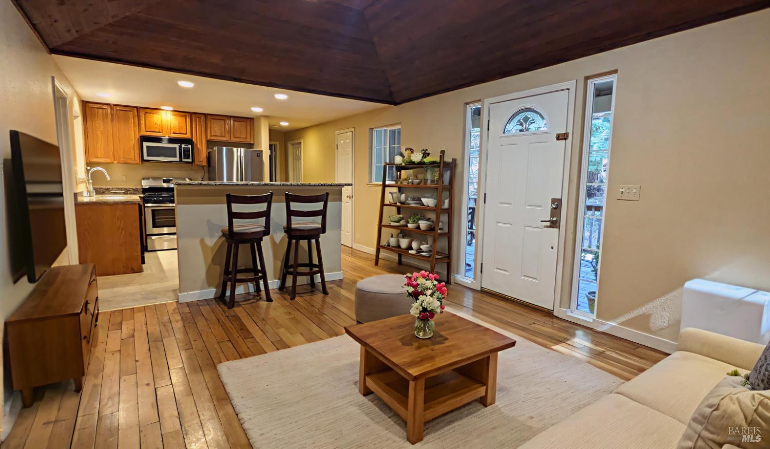 19026 Hidden Valley Road Guerneville, CA 95446 - Photo 7 of 23 a living room with furniture a wooden floor and kitchen view