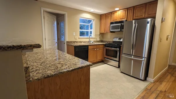 a bathroom with a granite countertop bathtub shower sink and toilet