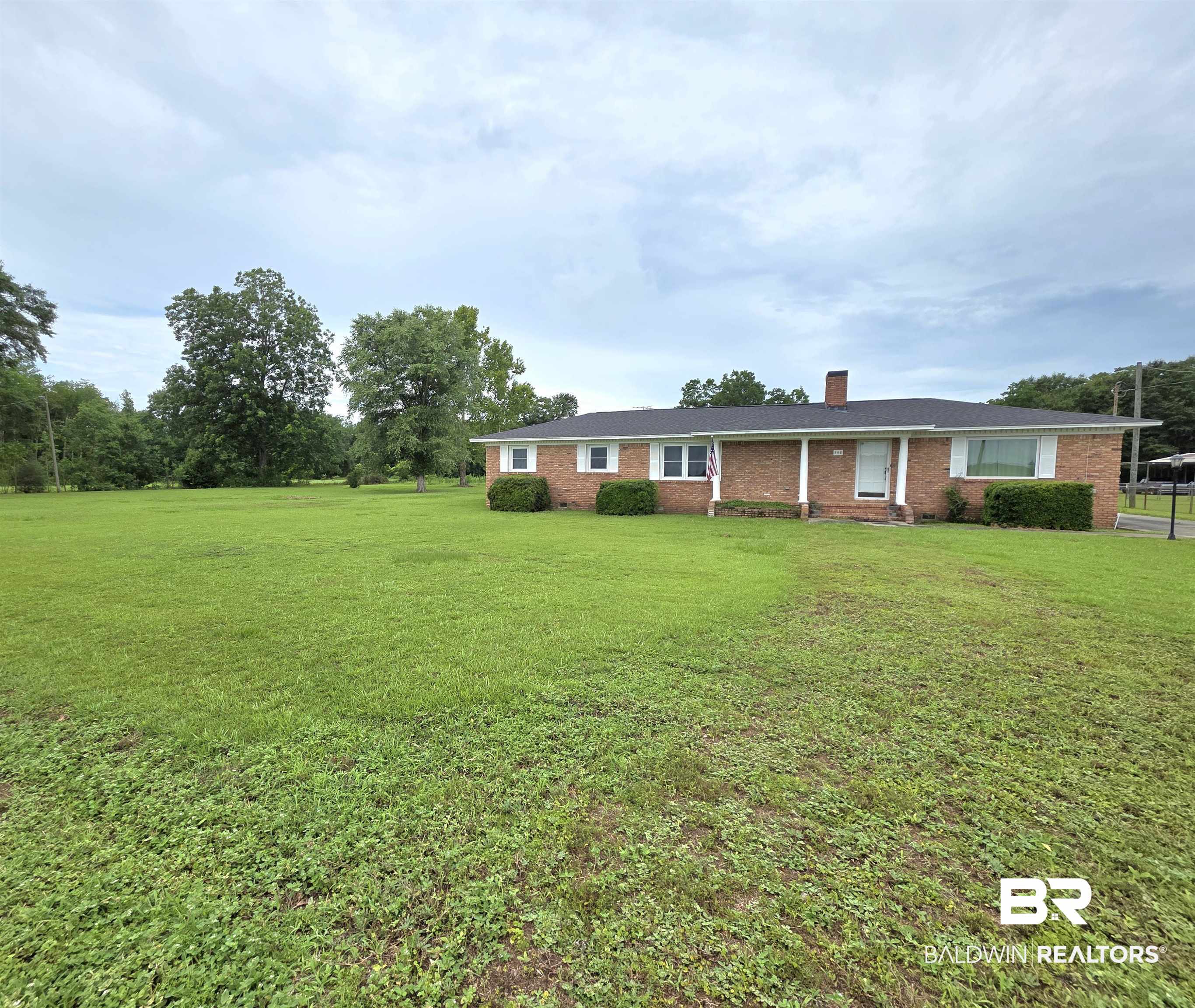 558 Stanton Road Atmore, AL 36502 - Photo 2 of 29 Brick-front residence set on an expansive green lawn with mature trees