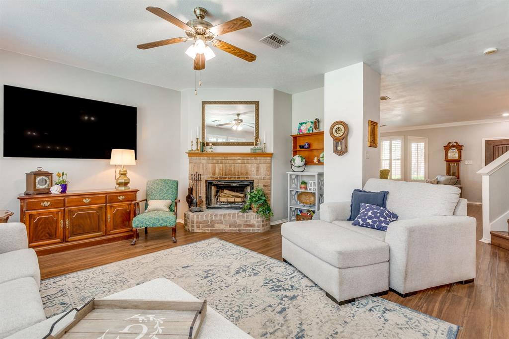 4816 Sleepy Ridge Circle Fort Worth, TX 76133 - Photo 11 of 36 Living area with wood finished floors, a fireplace, and ceiling fan