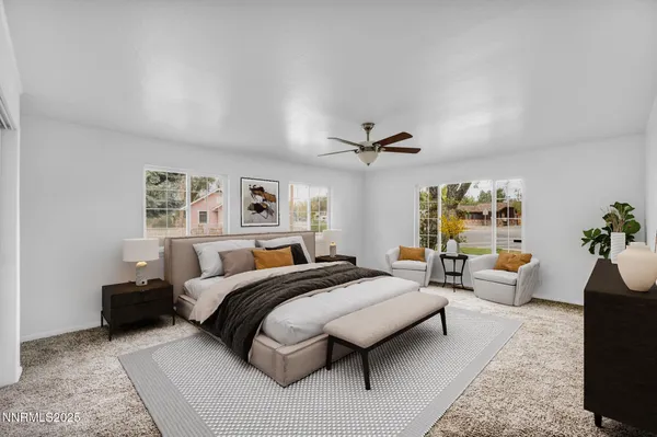 a spacious bedroom with a bed a couch and a potted plant