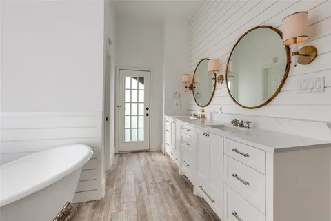 a bathroom with a double vanity sink a mirror a bathtub and shower