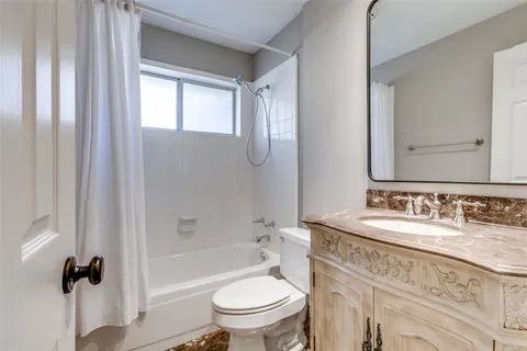 a bathroom with a granite countertop toilet a sink and a mirror