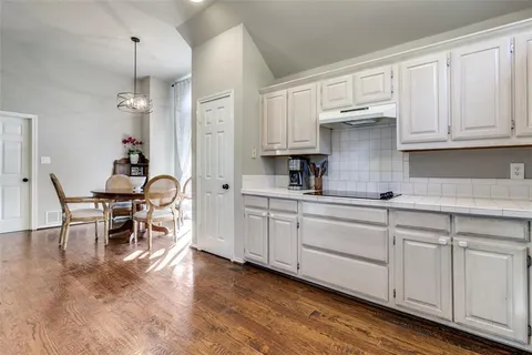 a kitchen with white cabinets and sink