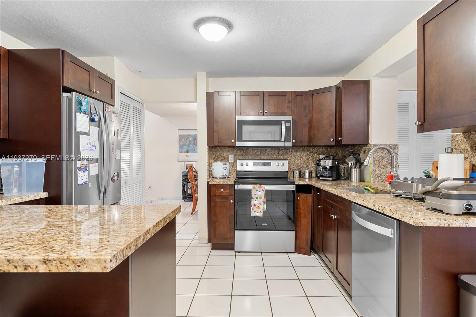 14256 Southwest 92nd Street Miami, FL 33176 - Photo 14 of 56 a kitchen with stainless steel appliances granite countertop a sink stove refrigerator and cabinets