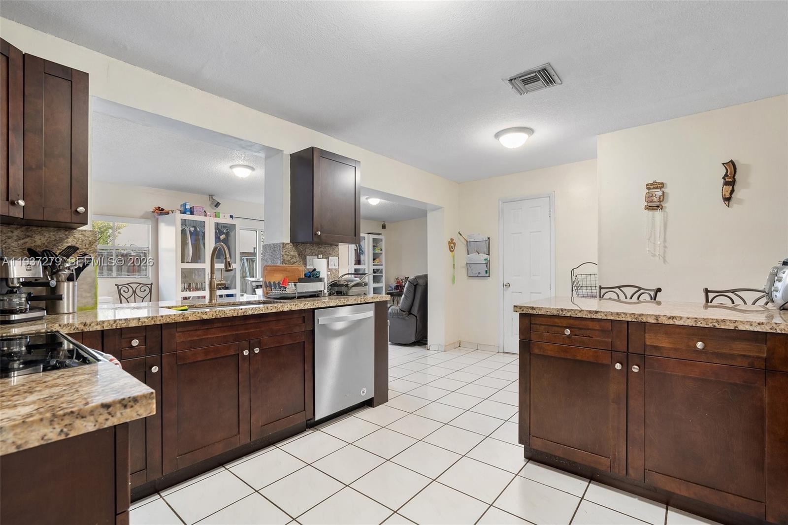 14256 Southwest 92nd Street Miami, FL 33176 - Photo 16 of 56 a kitchen with stainless steel appliances granite countertop a sink and cabinets