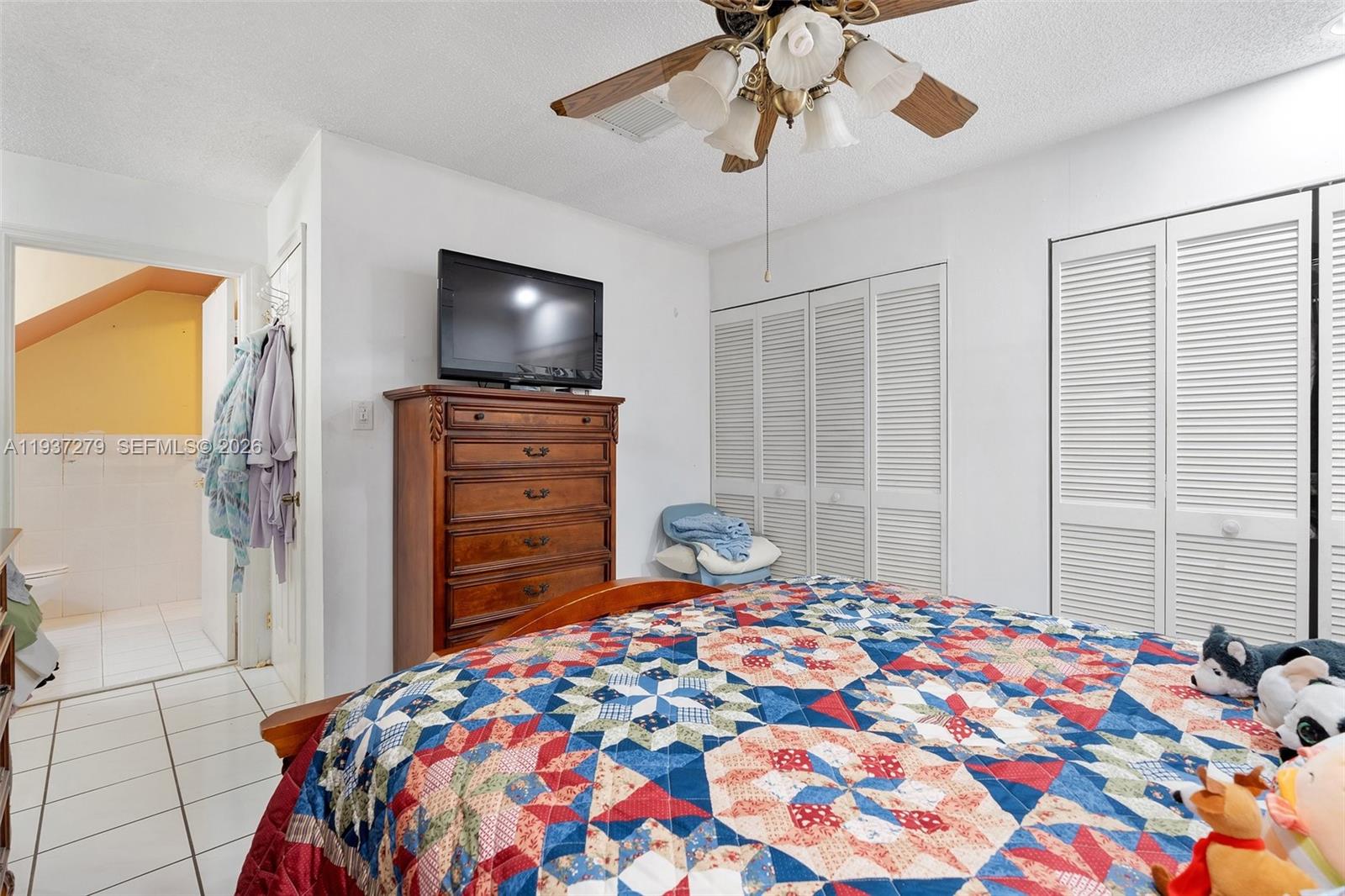 14256 Southwest 92nd Street Miami, FL 33176 - Photo 19 of 56 a bedroom with a bed and a flat screen tv