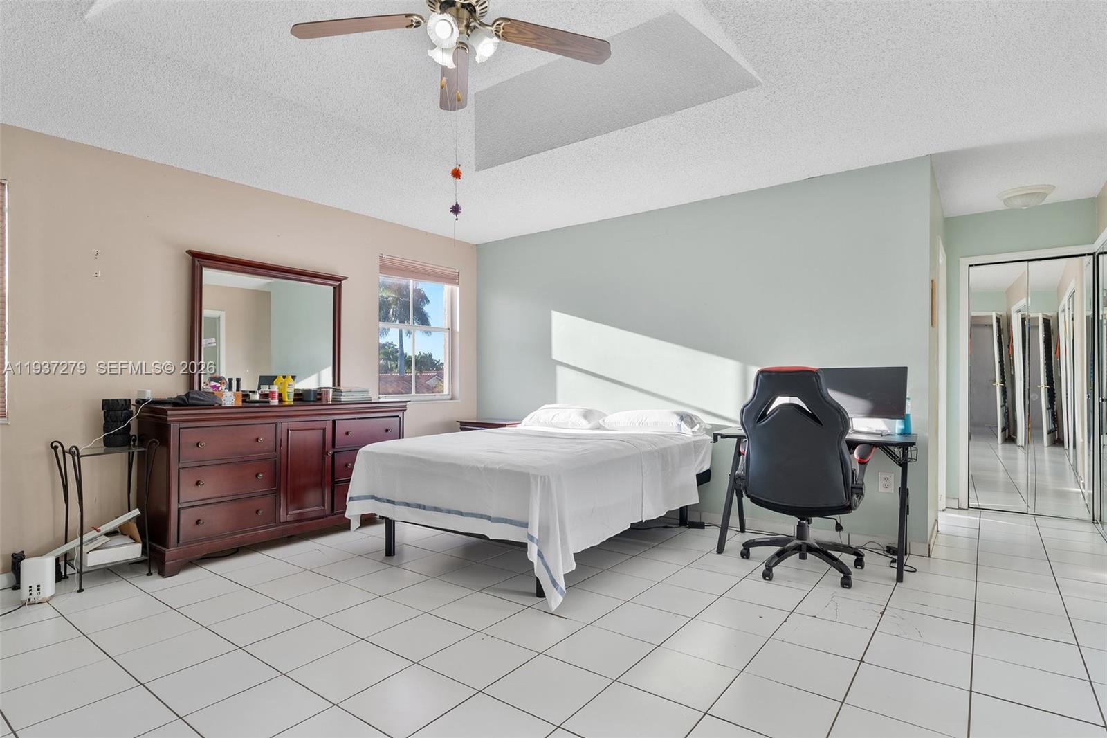 14256 Southwest 92nd Street Miami, FL 33176 - Photo 27 of 56 a bedroom with a bed and a chandelier