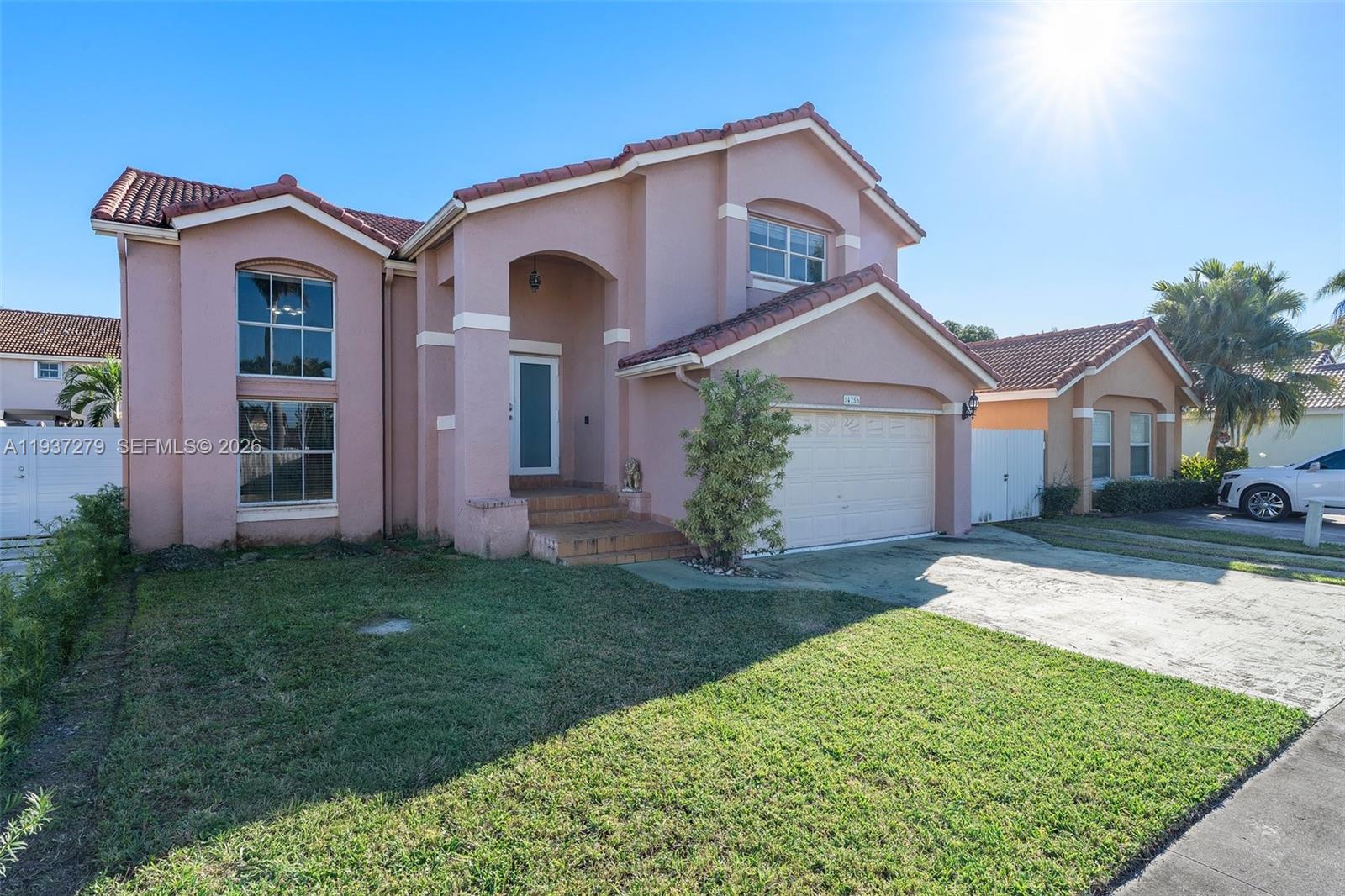 14256 Southwest 92nd Street Miami, FL 33176 - Photo 3 of 56 a front view of a house with a yard