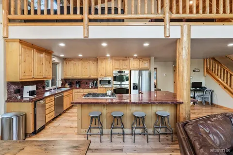a kitchen with stainless steel appliances granite countertop a refrigerator sink and stove