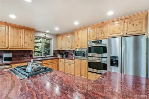 a kitchen with stainless steel appliances kitchen island granite countertop a stove sink and cabinets
