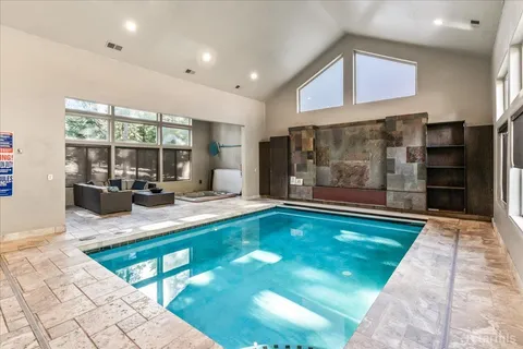 a large hall with stainless steel appliances granite countertop a sink and a white cabinets