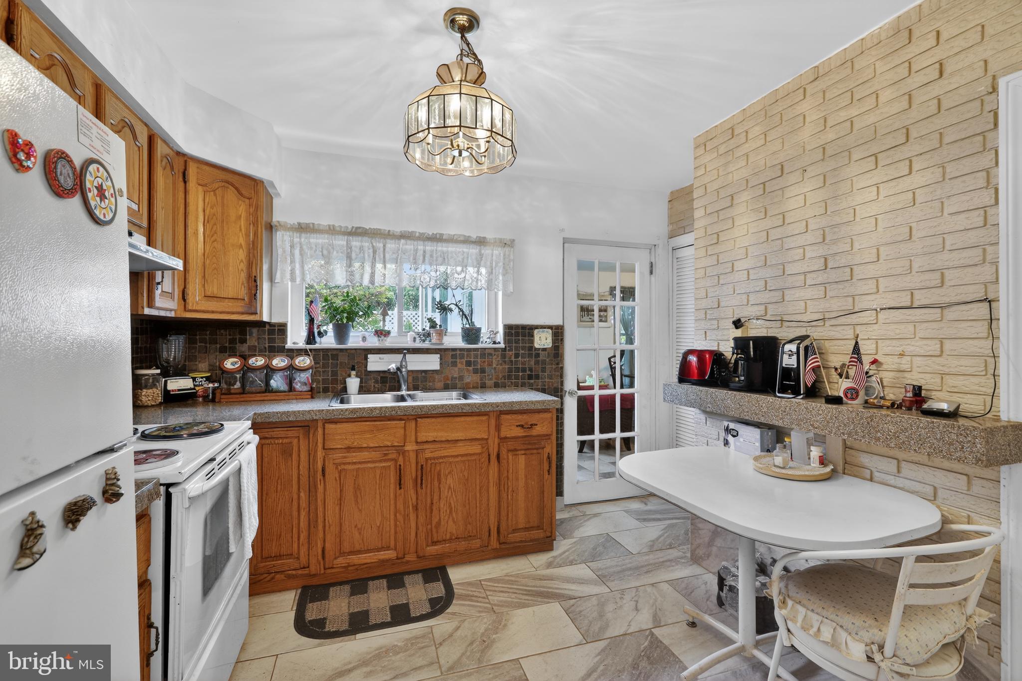 1424 Burmont Road Havertown, PA 19083 - Photo 10 of 37 a kitchen with a sink refrigerator and cabinets