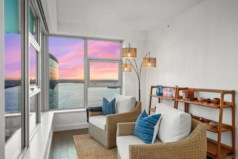 a living room with furniture and a floor to ceiling window