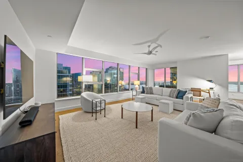a living room with fireplace furniture and a large window