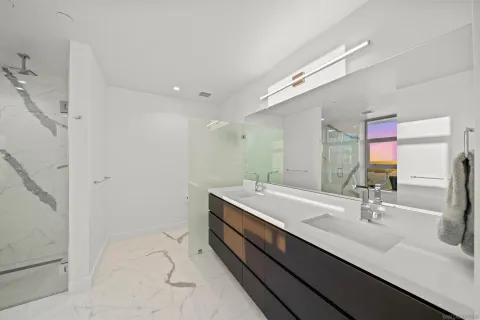 a bathroom with a double vanity sink a mirror and a shower