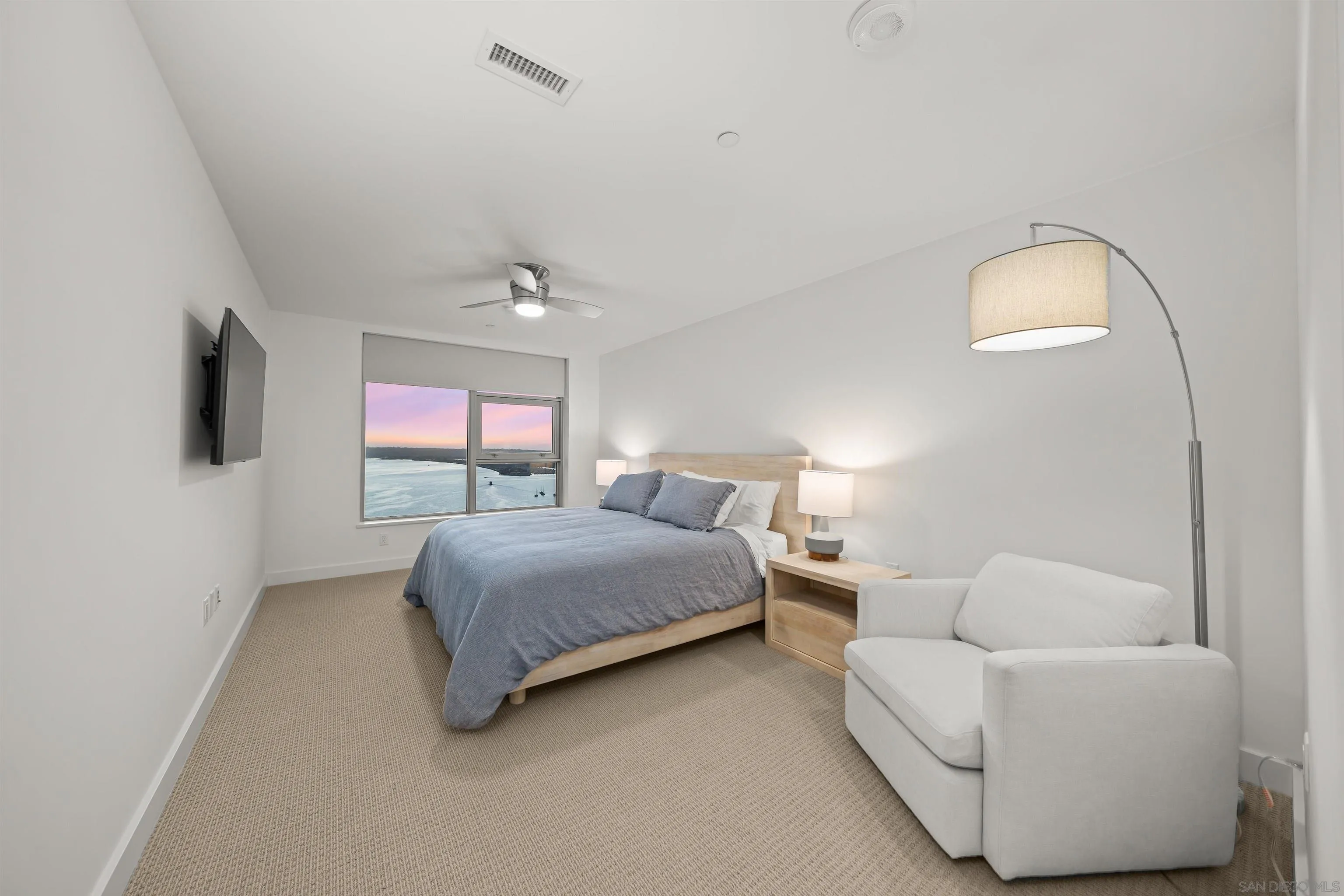 1388 Kettner Boulevard, Unit 3205 San Diego, CA 92101 - Photo 29 of 53 a spacious bedroom with a bed and a flat screen tv